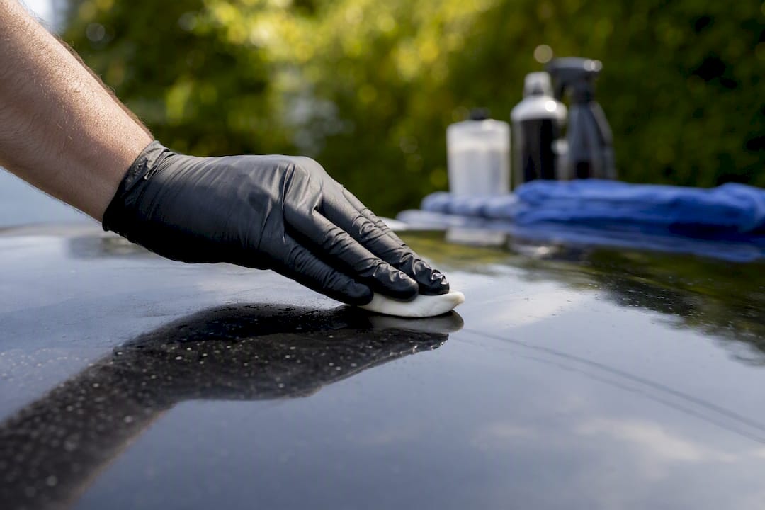 Detailer using clay bar to prep car paint