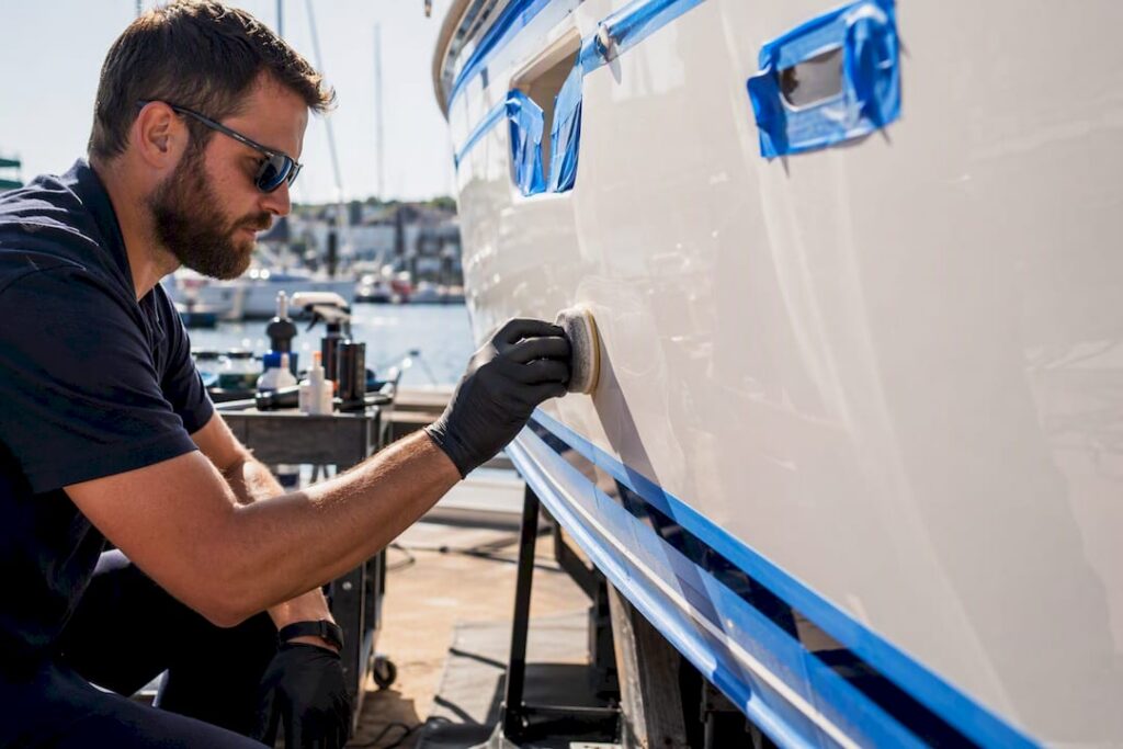 Detailer applying oxidation remover on boat hull