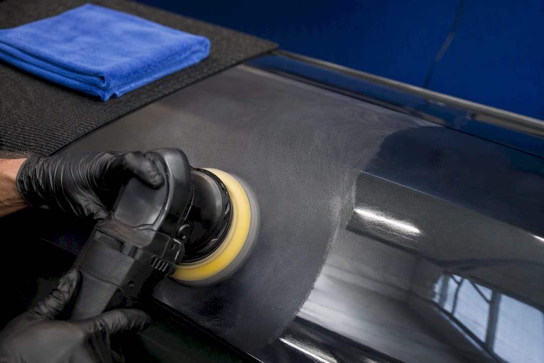Detailer performing paint correction on panel