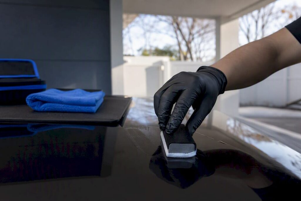 Detailer applying ceramic coating to vehicle panel