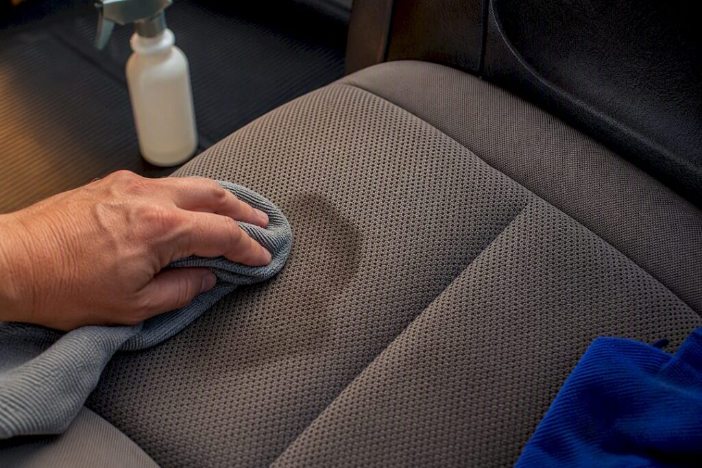 Detailer blotting stained car seat upholstery