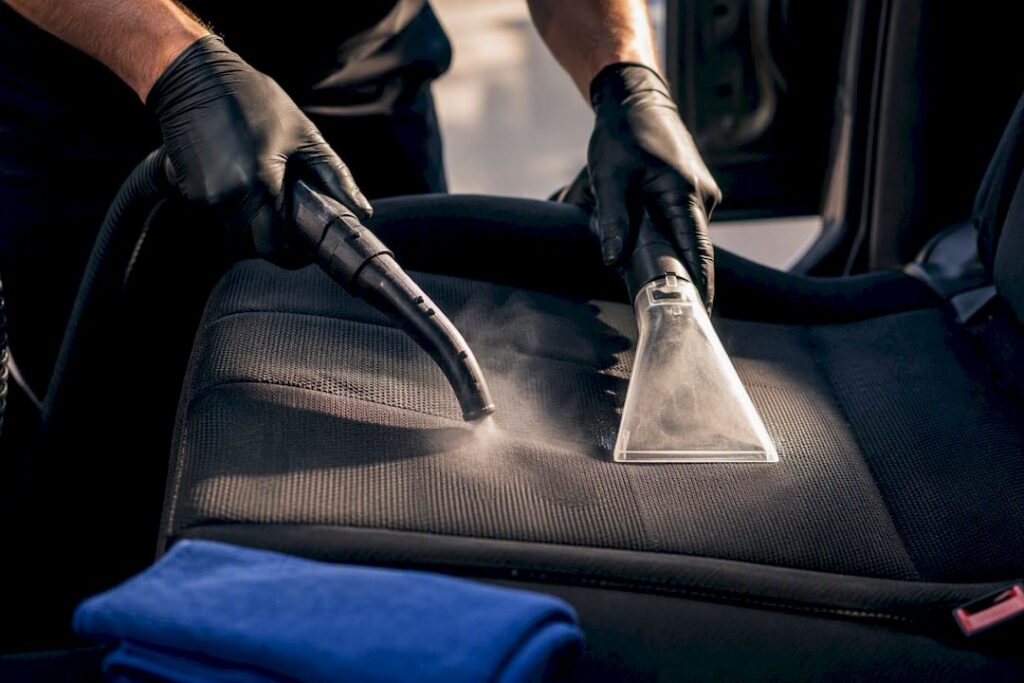 Steam and extraction tools cleaning an anonymous car seat