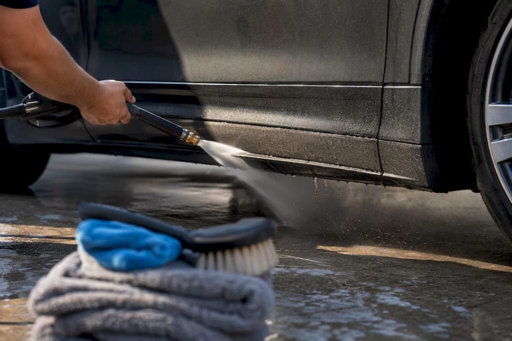 Technician rinsing an anonymous vehicle panel