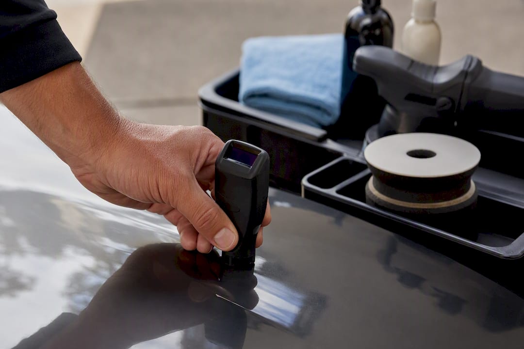 Detailer measuring paint depth before correction