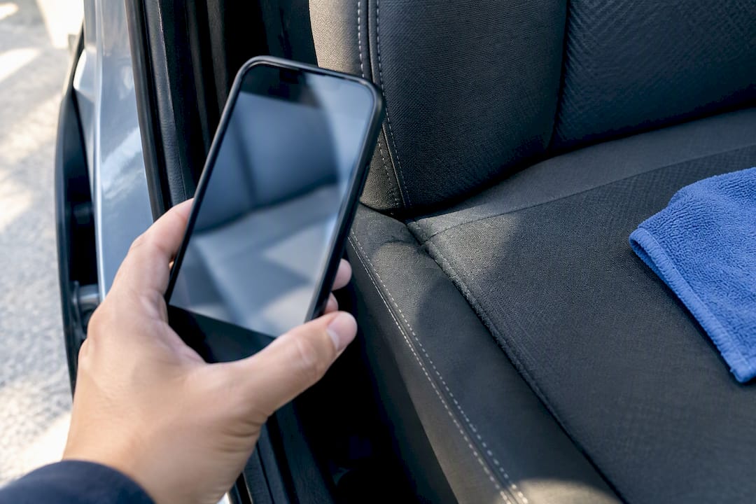 Owner photographing vehicle upholstery odor source